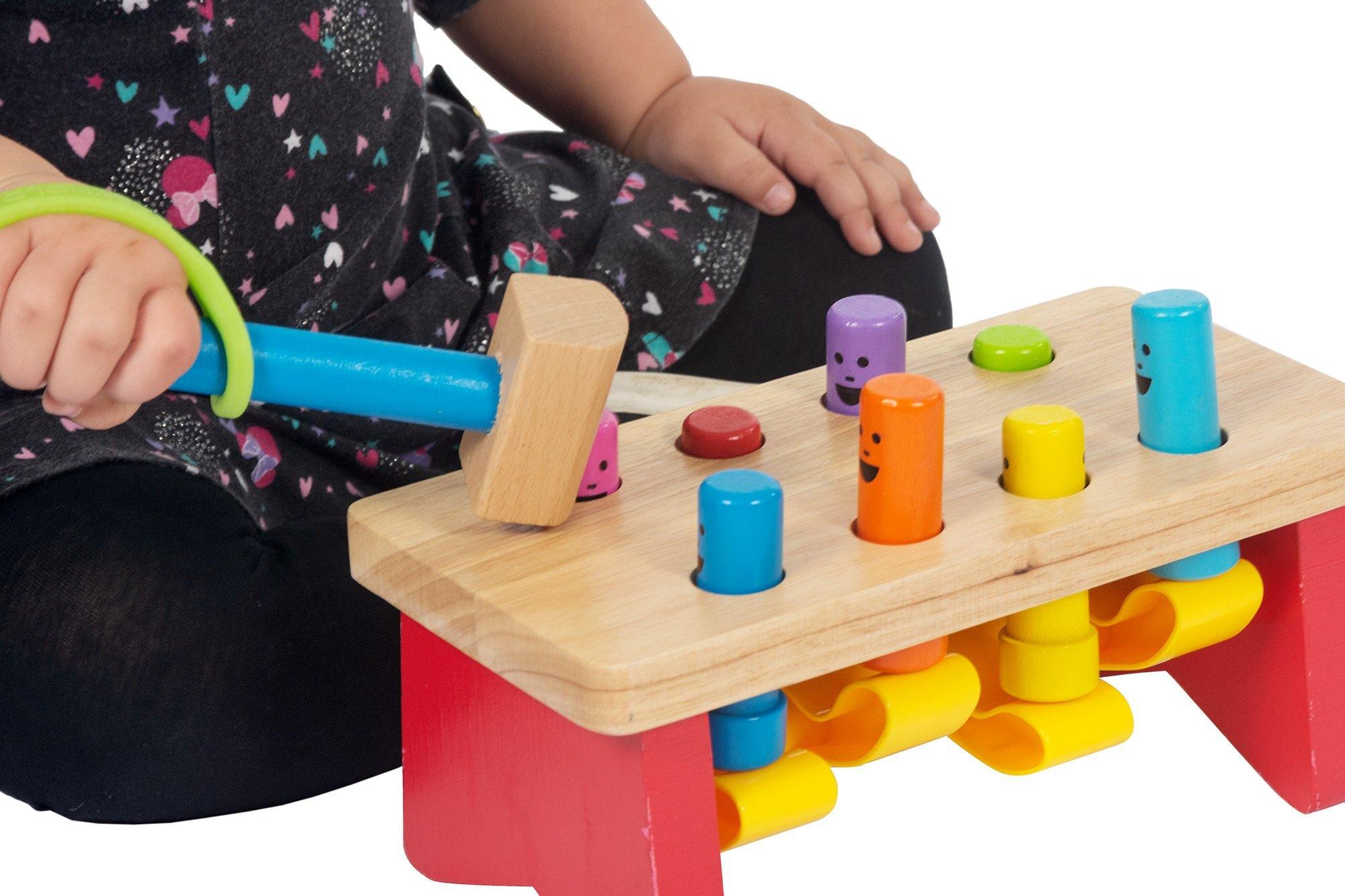 Child with poor grip playing with a toy using a green silicon band over her hand.