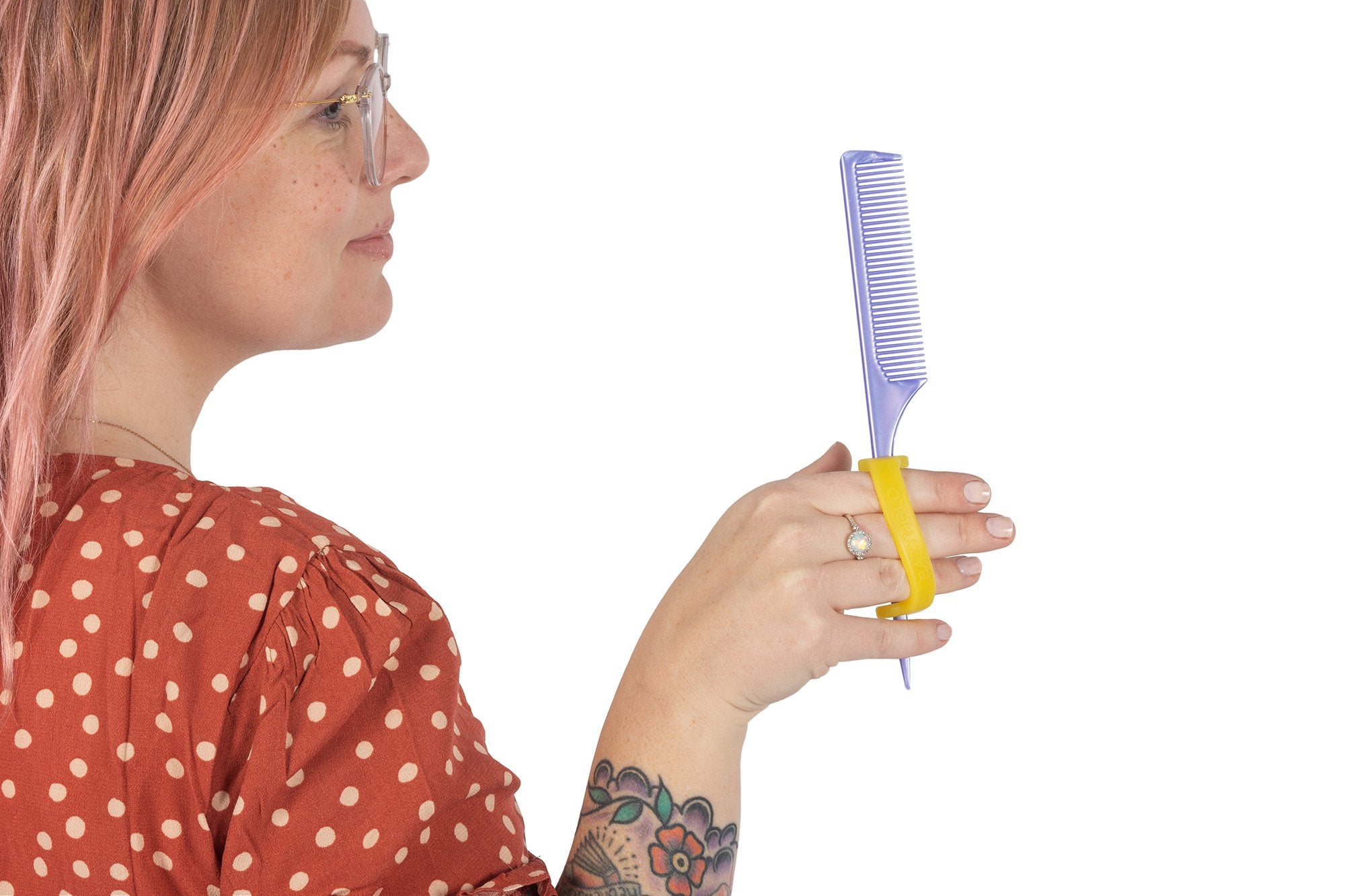 Hairdresser with a disability holds her comb adapted with an eazyhold ADL.