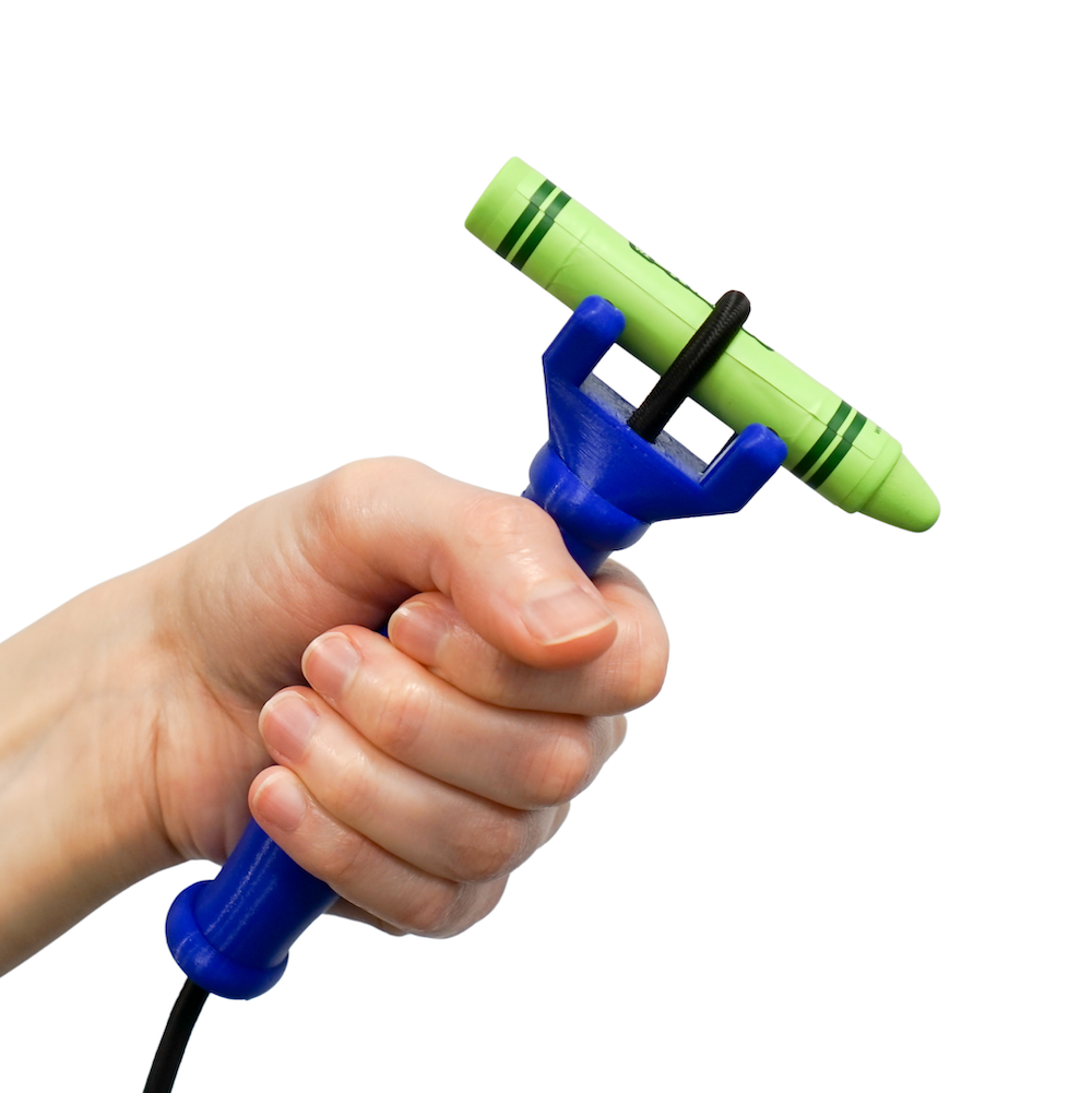 Hand holding a green crayon with a blue Functionalhand handle over a white background.