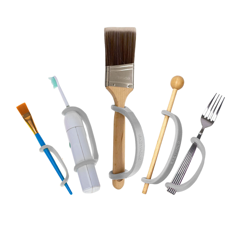 Five different sizes of light grey silicone EasyHold straps on various items over a white background, including a paintbrush, electric toothbrush, larger paintbrush, music mallet, and fork.