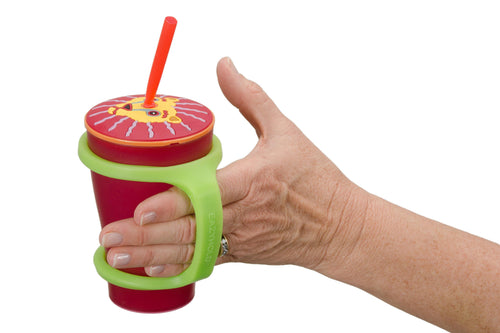 Hand with grip disability holds a sippy cup with the Large green eazyhold bottle holder.