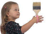 Child grasps paint brush using a silicone gripping aid.