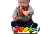 Infant with grip disabilities plays the xylophone using a soft uniersal cuff.