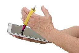 Hands using a yellow assistive deviceto write with a stylus on a tablet.