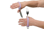 alt="Womans hands holding a knife and fork with the aid of EazyHold lavender eating silicone cuff"